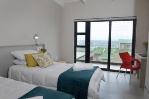 a bedroom with a bed and a view of the ocean at The Whale and Waddler in Kleinmond