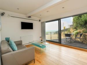 a living room with a couch and a glass table at Burton Bay in Burton Bradstock
