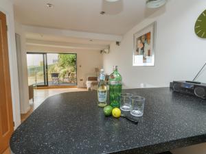 a kitchen counter with two bottles and glasses on it at Burton Bay in Burton Bradstock