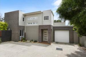 a large white house with a garage at CALYPSO RETREAT - Modern townhouse - Ocean views in Portarlington
