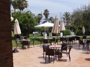 a patio with tables and chairs and umbrellas at Mas Gallau in Cambrils