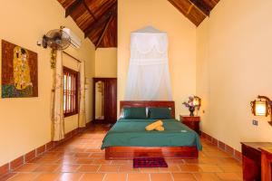 a bedroom with a bed with a curtain on the wall at Kiki Coconut Beach Resort in Phu Quoc