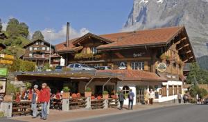 a group of people walking in front of a building at Hotel Steinbock Grindelwald in Grindelwald