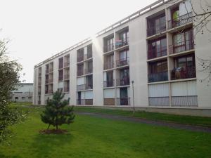 un edificio de apartamentos con un árbol delante de él en Cosylocation Jean Bart 59, en Rennes