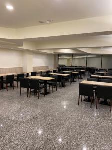 an empty classroom with tables and chairs in a room at Jin Zhan Hotel in Jincheng