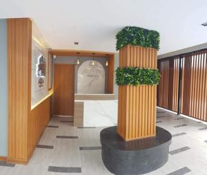 a lobby with two large pillars with plants on them at Aqua Residences อควา เรสซิเดนซ์ ห้องพักใหม่ให้เช่า ติดรถไฟฟ้าสถานีวุฒากาศ in Thonhuri