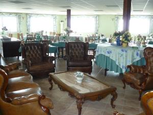 una habitación con sillas y mesas de cuero y un asterisco en Hotel Villaclara, en Hospitalet de l'Infant