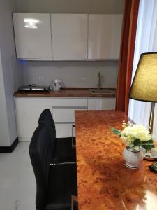 a kitchen with a wooden table and a black chair at Apartament prywatny z aneksem kuchennym w hotelu Royal Tulip Sand in Kołobrzeg