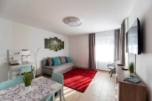 a living room with a couch and a table at Lovely apartman- free parking in Pécs