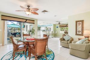 a living room with a table and chairs at Palm Breeze Bliss in Marco Island