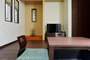 uma sala de estar com uma mesa e uma televisão em Ya -MIYABI em Quioto