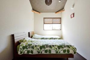 a small bedroom with two beds and a window at Ya -MIYABI in Kyoto