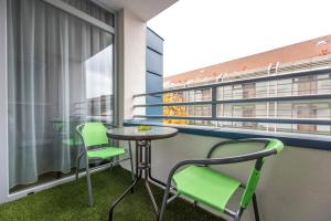 balcón con mesa, 2 sillas y ventana en Lovely apartman- free parking en Pécs