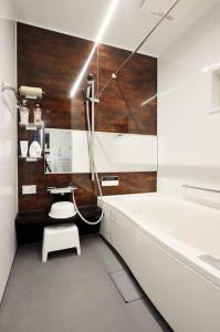 a bathroom with a tub and a toilet and a sink at Ya -MIYABI in Kyoto