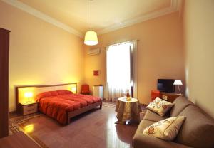 a bedroom with a bed and a couch and a window at *1*7*4* Via Roma in Palermo