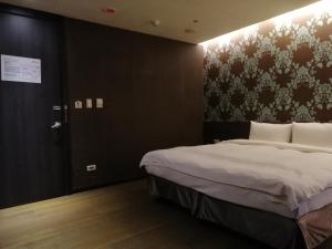 a bedroom with a bed and a door with a wall at Shan-Yue Hotspring Hotel in Taipei