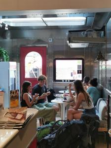 a group of people sitting at tables in a train at Tales Khaosan (Cafe & Hostel) in Bangkok