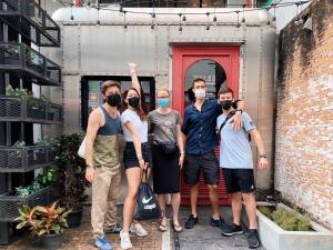 a group of people standing in front of a red door at Tales Khaosan (Cafe & Hostel) in Bangkok