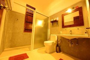a bathroom with a shower and a toilet and a sink at Nil Diya Mankada Safari Lodge in Udawalawe