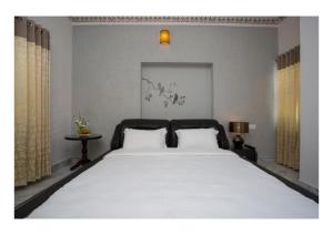 um quarto com uma grande cama branca e 2 almofadas em Braj Villa 5BHK em Hāmīrgarh