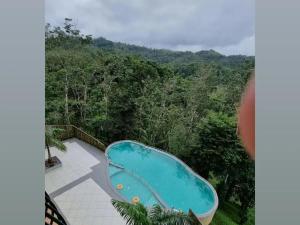 vista para uma piscina no meio da floresta em Serene Crest Resort em Mananthavady