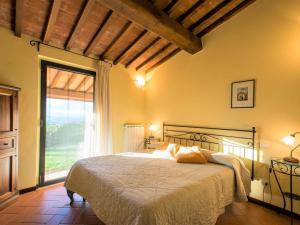 ein Schlafzimmer mit einem Bett und einem großen Fenster in der Unterkunft Belvilla by OYO Lago in Bagnolo