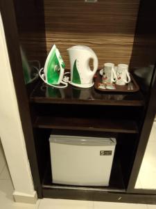 a shelf with cups and other items on it at Gold Coast Morib International Resort 摩立黄金海岸度假屋 in Banting