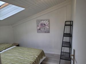 a bedroom with a bed and a painting on the wall at Gîte Mélisse in Mouilleron-le-Captif