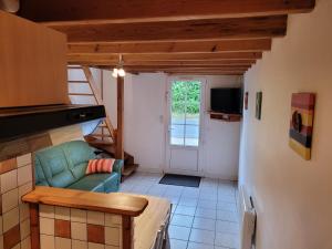 a living room with a couch and a refrigerator at Gîte Mélisse in Mouilleron-le-Captif