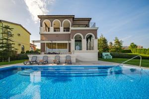 una casa con piscina frente a una casa en Lighthouse Luxe Estate Apart & Villas, en Balchik