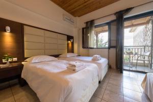 a bedroom with two beds and a balcony at Thermios Apollon in Thermo