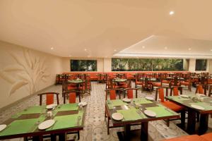 a restaurant with green tables and chairs in it at Jade Suites - Luxury Boutique Hotel in Vijayawāda