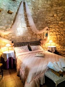 a bedroom with a bed in a stone wall at Torre Rodosta in Modica