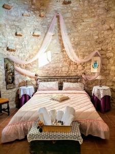 ein Schlafzimmer mit einem großen Bett und einer Steinmauer in der Unterkunft Torre Rodosta in Modica