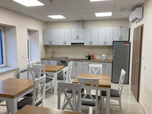 une cuisine et une salle à manger avec des tables et des chaises dans l'établissement Hotel Aljan, à Wiązownica