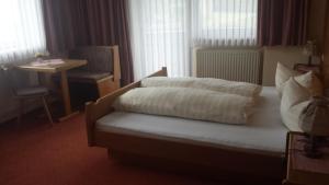 a hotel room with a bed and a table and window at Gästehaus Annabell und Barbara in Sautens