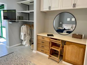 a dressing room with a vanity and a mirror at Sandra's Guest House in Langebaan