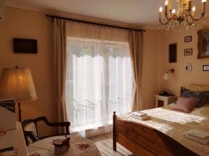 a bedroom with a bed and a large window at Eperkert Vendégház in Parád