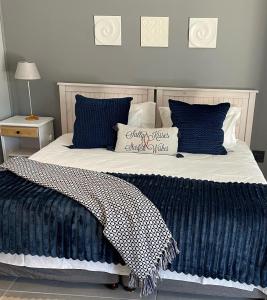 a bedroom with two beds with blue and white pillows at Sandra's Guest House in Langebaan