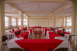 a room with red and white tables and chairs at The Sparrow Hotels in Soroti