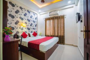 a hotel room with a bed and a window at Almas Residency in Cochin