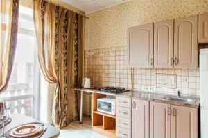 una cocina con armarios blancos y fregadero en TRUSThome, en Minsk