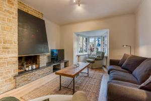 een woonkamer met een bank en een open haard bij Chalet des Roses - Fantastic & renewed Villa 7p in De Haan
