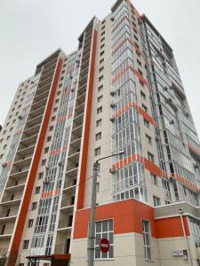 a tall apartment building with an orange and gray facade at Studio Black&White in Voronezh