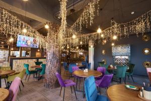 a restaurant with tables and chairs and chandeliers at Хостел Впечатления in Yekaterinburg