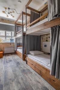 two bunk beds in a room with wooden floors at Хостел Впечатления in Yekaterinburg