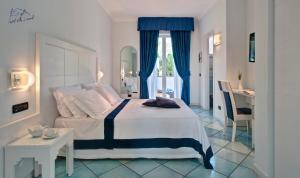 een slaapkamer met een bed, een tafel en een bureau bij Hotel Villa Durrueli Resort & Spa in Ischia