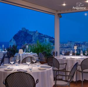 a restaurant with white tables and chairs with a view at Hotel Villa Durrueli Resort & Spa in Ischia