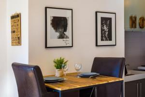 een eettafel met 2 stoelen en een tafel met wijnglazen bij Studio industriel, vue sur l’étoile, Moustiers #4 in Moustiers-Sainte-Marie