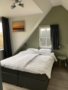 a bedroom with a bed in a attic at Dijkhofje, dichtbij strand, zee en meer. in Vrouwenpolder